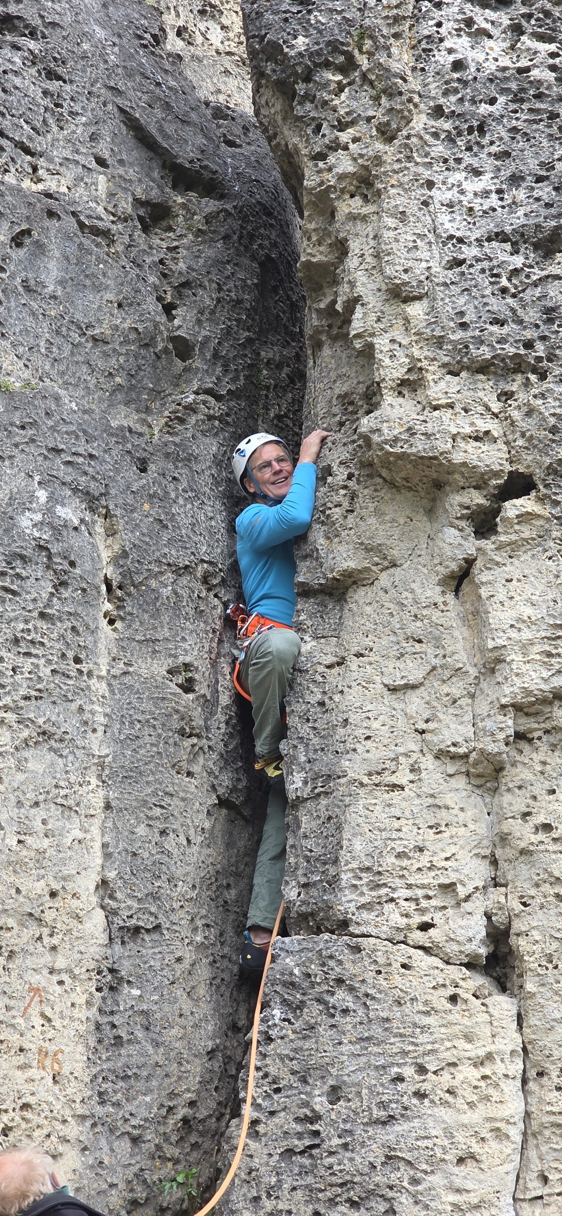 Kletterin im Vorstieg an einer Sandsteinwand, gesichert mit Seil